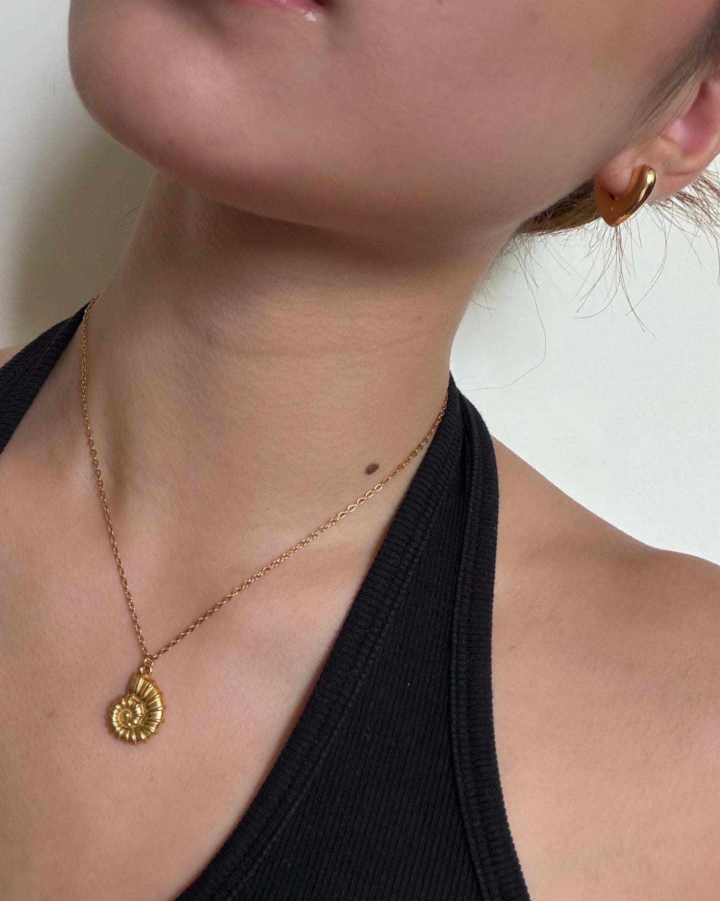Silhouette Spark KAIA necklace 金色款上身示範，黑色背心搭配金色鸚鵡螺吊墜項鍊，近距離頸部特寫