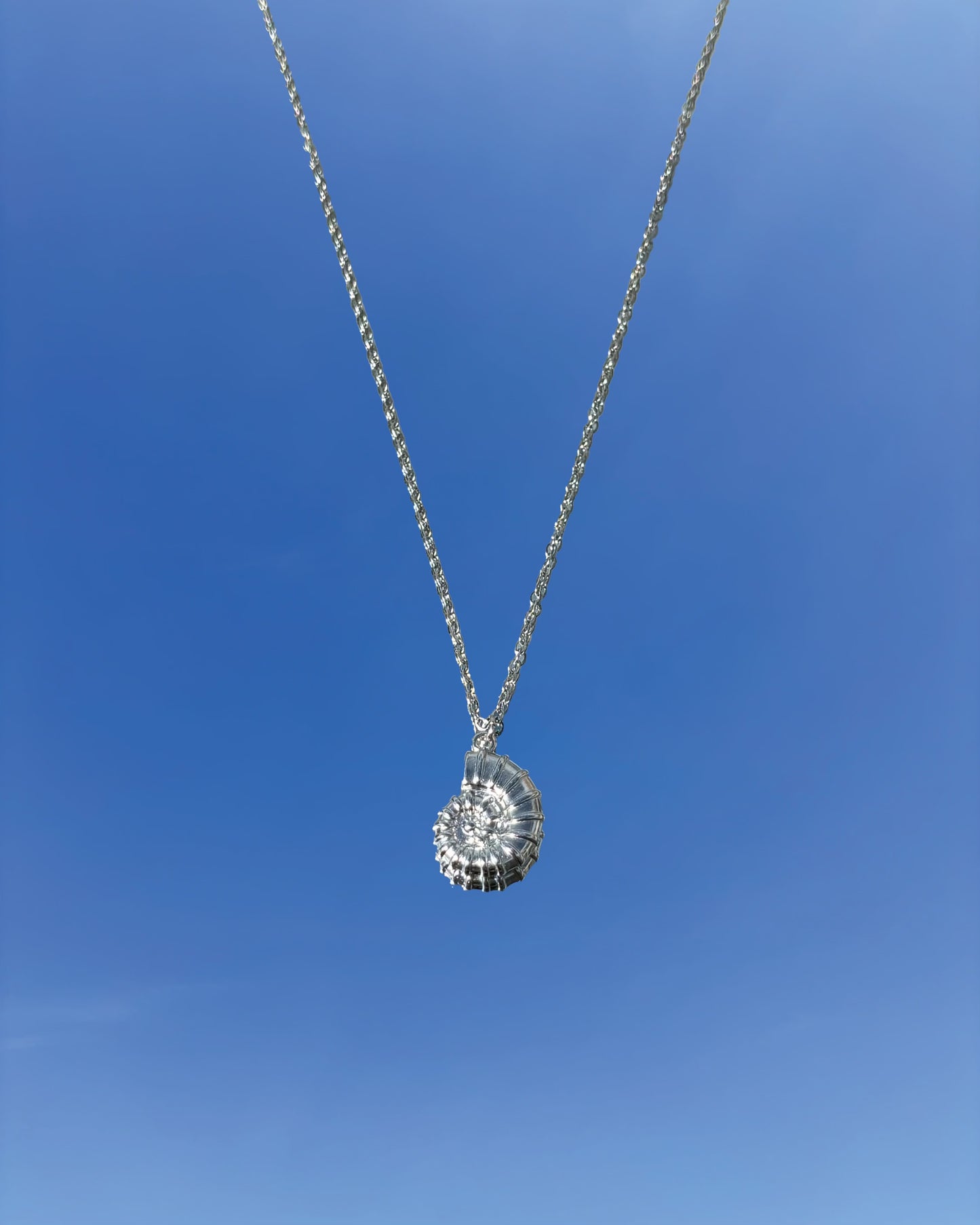 Silhouette Spark KAIA necklace 銀色鸚鵡螺貝殼吊墜項鍊，銀色鍊條，藍天背景