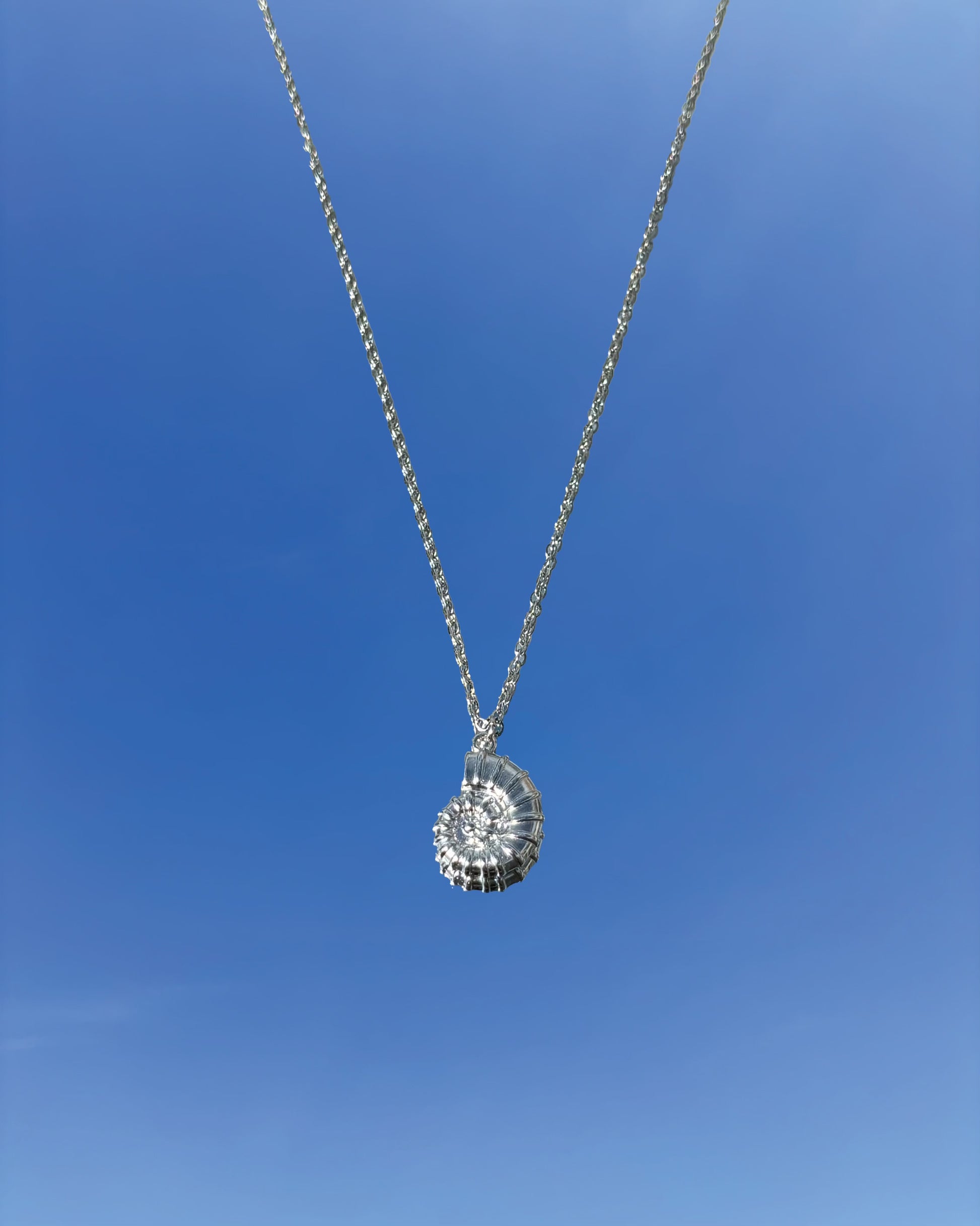 Silhouette Spark KAIA necklace 銀色鸚鵡螺貝殼吊墜項鍊，銀色鍊條，藍天背景