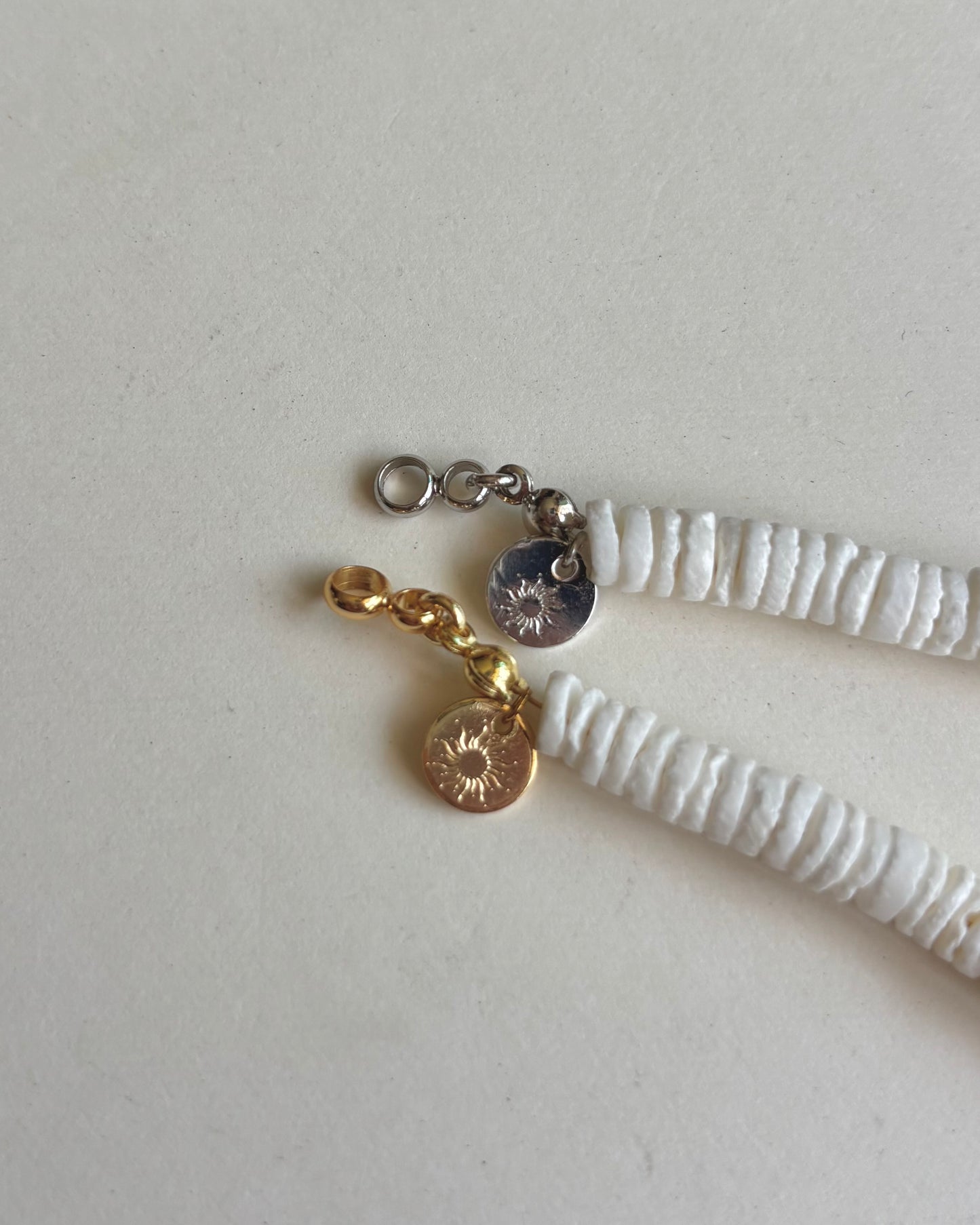 Silhouette Spark LA MER necklace 品牌 tag 特寫，金色與銀色款扣環對比，白色背景