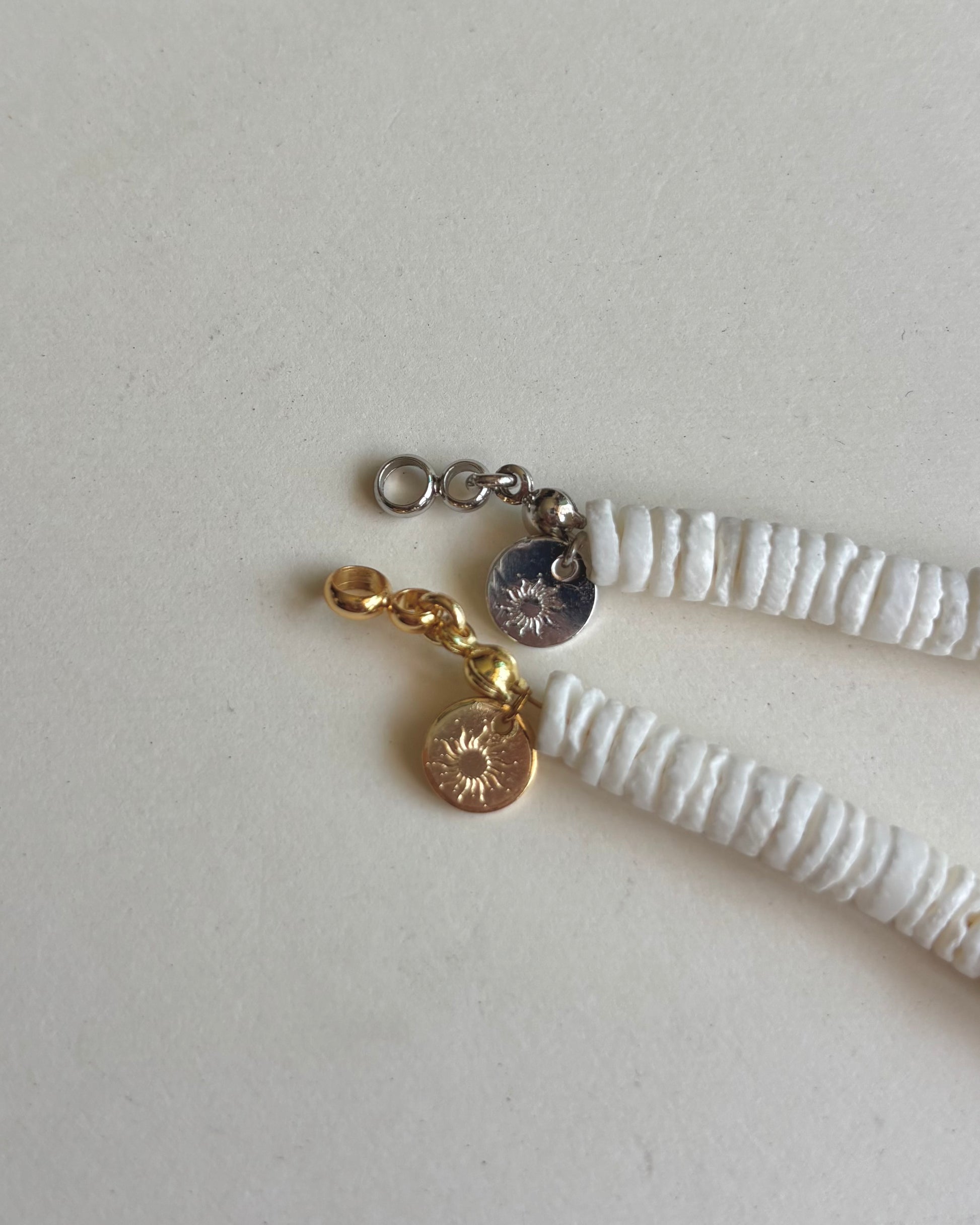 Silhouette Spark LA MER necklace 品牌 tag 特寫，金色與銀色款扣環對比，白色背景