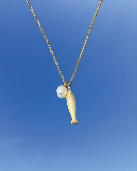 Silhouette Spark THEA necklace 金色魚形吊墜搭配珍珠圓珠項鍊，金色鍊條，藍天背景